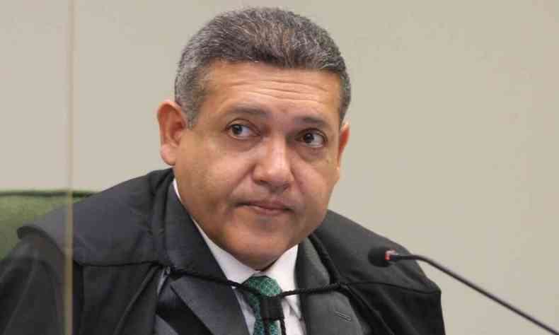 Ministro Nunes Marques em sua cadeira no Supremo com a toga e em frente ao microfone