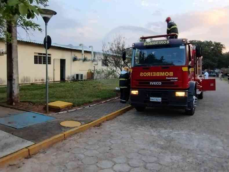 homem em cima de um caminho dos bombeiros esguichando gua em um imvel