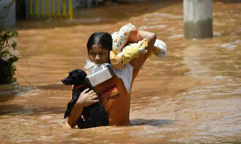 Mulher carrega cachorro, alguns pertences e o celular na boca para se salvar de inundao no Bairro So Tarcsio 