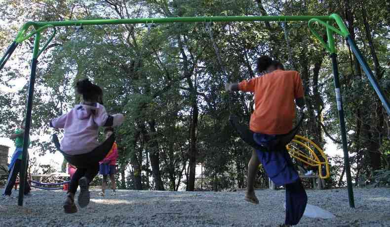 Crianas em um balano em parque.