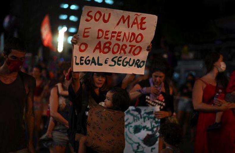 Manifestante com cartaz escrito Sou Me e defendo o aborto legal e seguro