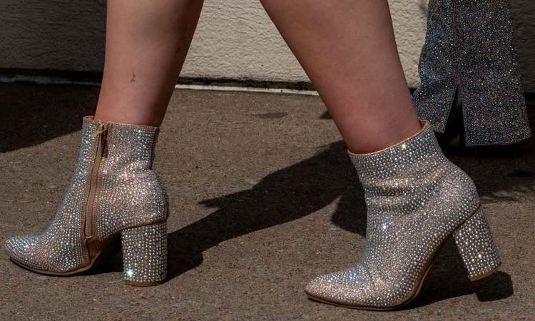 Foto dos ps de f com botas prateadas como aquelas usadas por Taylor Swift