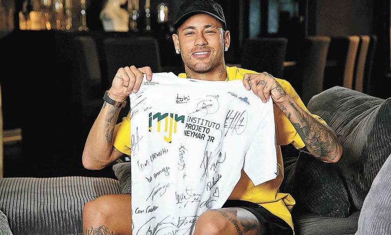 Neymar, jogador brasileiro, mostra camisa de projeto social