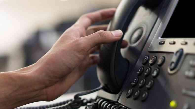 Mo segurando telefone usado em telemarketing