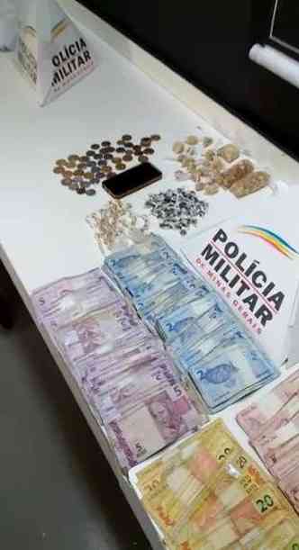 Quantia total de R$ 8305,00 e pores de crack e maconha encontrados com o preso pela PMMG(foto: Polcia Militar/Divulgao)
