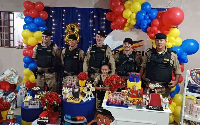 Policiais militares posam ao lado de criana em festa de aniversrio
