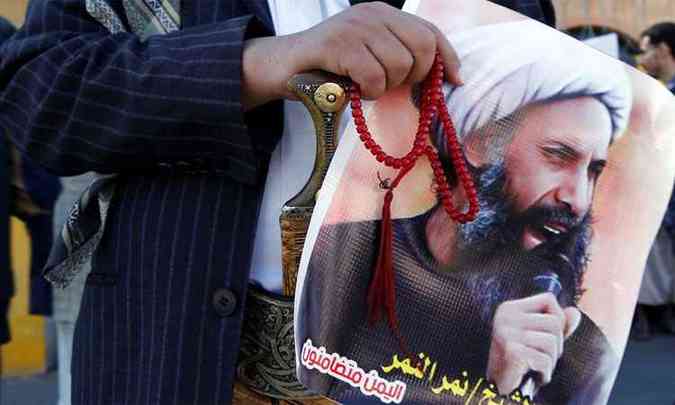 Manifestante exibe cartaz com imagem do clrigo xiita durante protesto contra a condenao dele em 2014(foto: REUTERS/Khaled Abdullah )