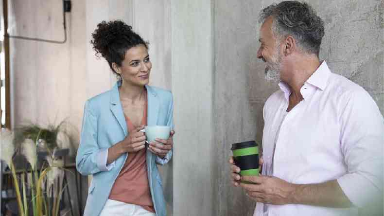 Homem e mulher flertando com uma caf na mo no escritrio
