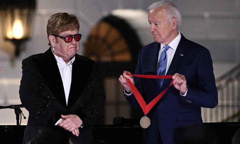 O cantor britnico Elton John se emociona quando o presidente dos EUA Joe Biden o presenteia com a Medalha Nacional de Humanidades no final de 'A Night When Hope and History Rhyme' na Casa Branca em Washington, DC, em 23 de setembro de 2022, onde o cantor se apresentou