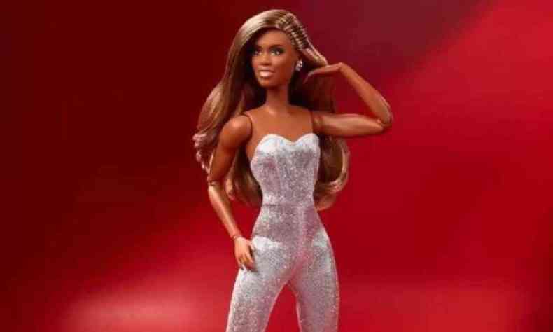 Barbie inspirada na atriz Laverne Cox, usando macaco prateado em um fundo vermelho 