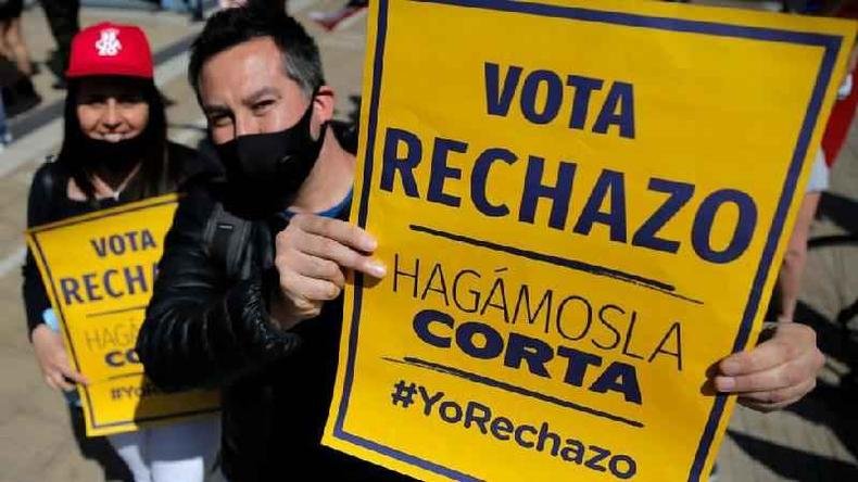 Casal segura cartaz afirmando: 'Vote rejeito; vamos encurtar (o processo)'(foto: Getty Images)