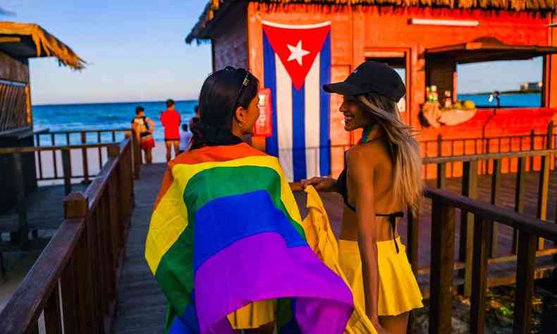 Pessoas caminham para a praia com uma bandeira de arco-íris no Gran Muthu Rainbow Hotel localizado Guillermo Key na província de Ciego de Avila, Cuba em 27 de novembro de 2021