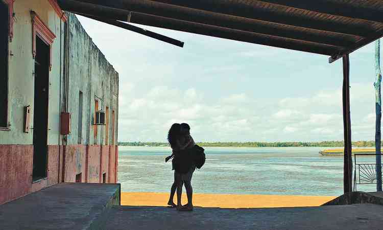 Casal se beija em frente a paisagem aqutica em cena de O rio do desejo
