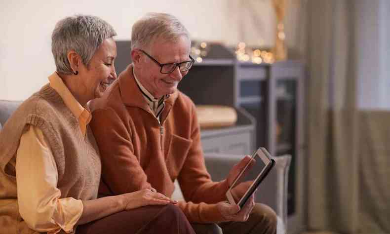 Casal de idosos assiste a vdeo em tablet