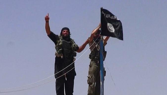 Militantes do EIIL, agora chamado de ''Estado Isl�mico'', hasteiam bandeira da jihad isl�mica em forte militar na fronteira entre S�ria e Iraque(foto: / HO / ALBARAKA NEWS)