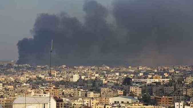 Quase 700 palestinos foram mortos desde o incio da ofensiva israelense em Gaza, sendo a maioria deles mulheres e crianas. Na foto, fumaa sobe por entre os prdios do Bairros de Shejaiya, atacado novamente nesta quarta-feira(foto: MAHMUD HAMS / AFP)