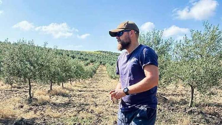 Tomy Rohde em meio a plantação de oliveiras
