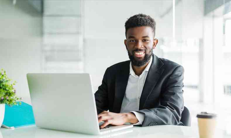 Homem negro de frente para notebook