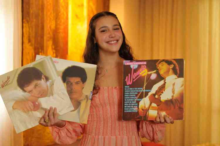 Maria Sabrina sorri e segura discos do pai, o cantor e compositor Wando