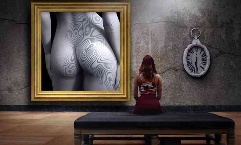 mulher observa tela de uma ndega tatuada