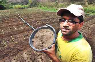 Celso de Moraes passou parte do dia de ontem plantando alfaces na terra ainda seca: atraso (foto: Leandro Couri/EM/D.A PRESS)