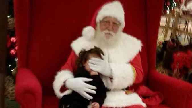 Papai Noel esconde o rosto de menina na momento que a foto  feita(foto: Reproduo/Facebook)