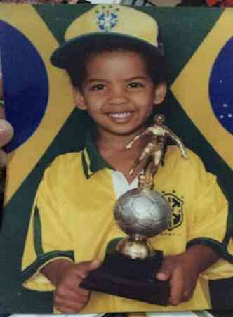 garota com camisa da seleção brasileira de futebol segurando um troféu