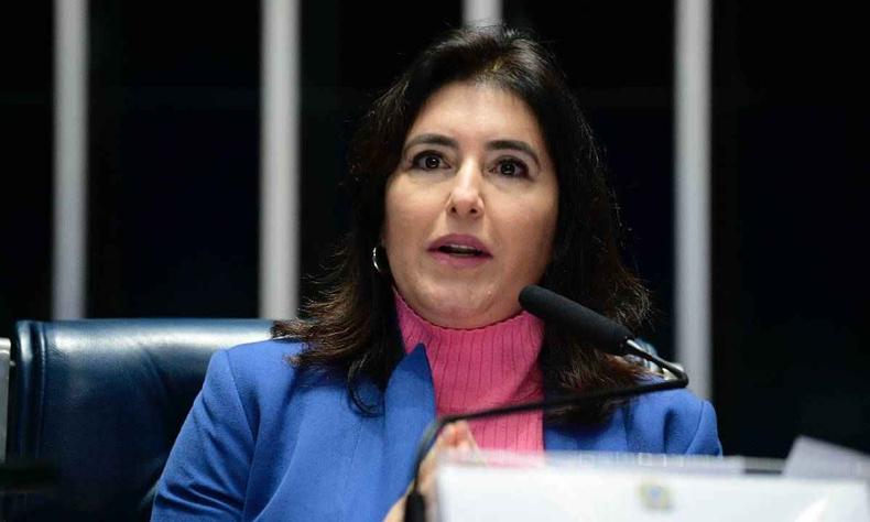 Simone Tebet usando uma blusa de gola alta rosa e um blazer azul
