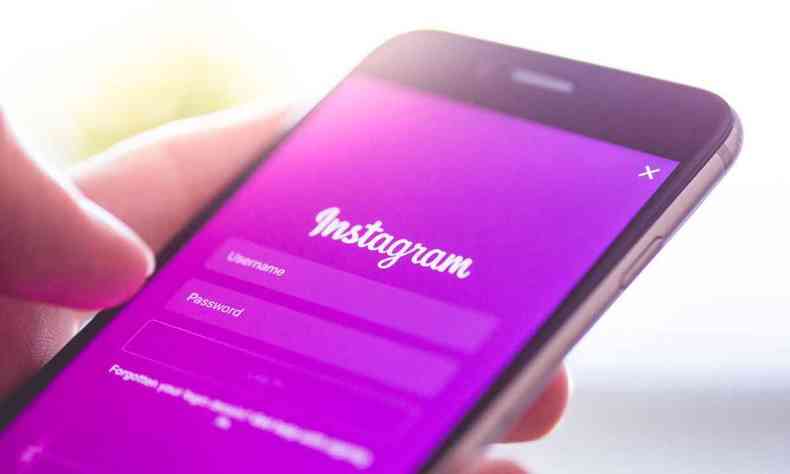 Instagram no celular, com fundo roxo 