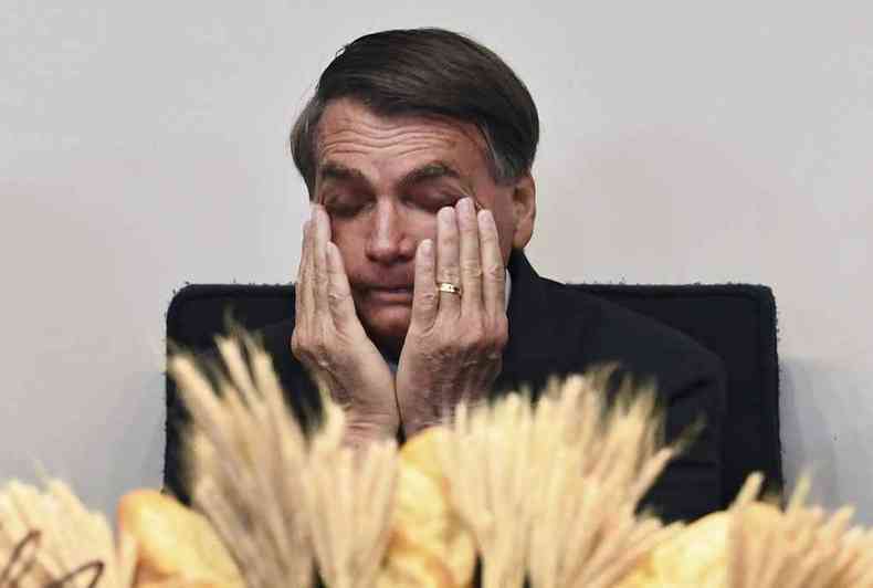 Bolsonaro esfrega o rosto com as mos