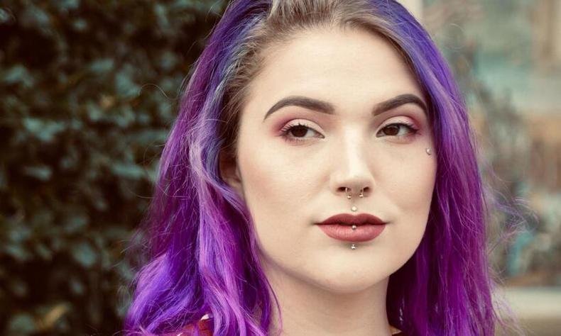 Na boca, há milhões de bactérias e, por isso, inflamações, inchaços e infecções ocorrem com frequência em piercings no local(foto: Andra C Taylor Jr/Unsplash) Mulher com piercing na boca