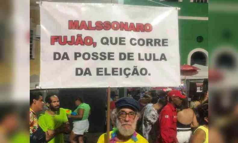 Folio segura placa com recado para Bolsonaro. Na placa est escrito: 'Malssonaro fujo, que corre da posse de Lula da eleio'.