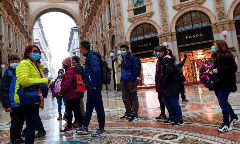 Turistas usam mscaras de proteo na Galeria Vittorio Emanuele, no centro de Milo(foto: AFP / Miguel MEDINA)