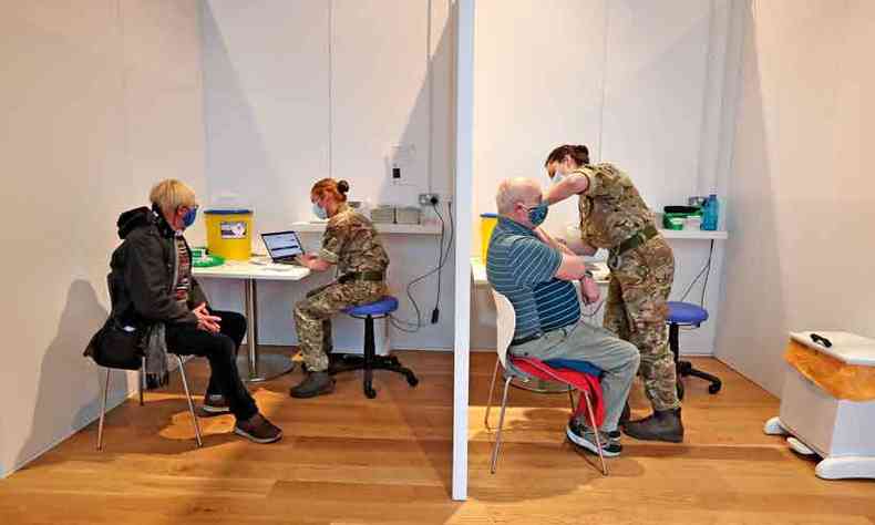 Militares aplicam vacina em moradores de Edimburgo: benefcios verificados nos ensaios clnicos mantidos em grande escala(foto: Andrew Milligan/AFP)