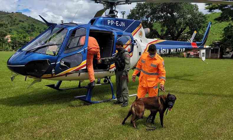 Militares e o cão Bono, diante do helicóptero 