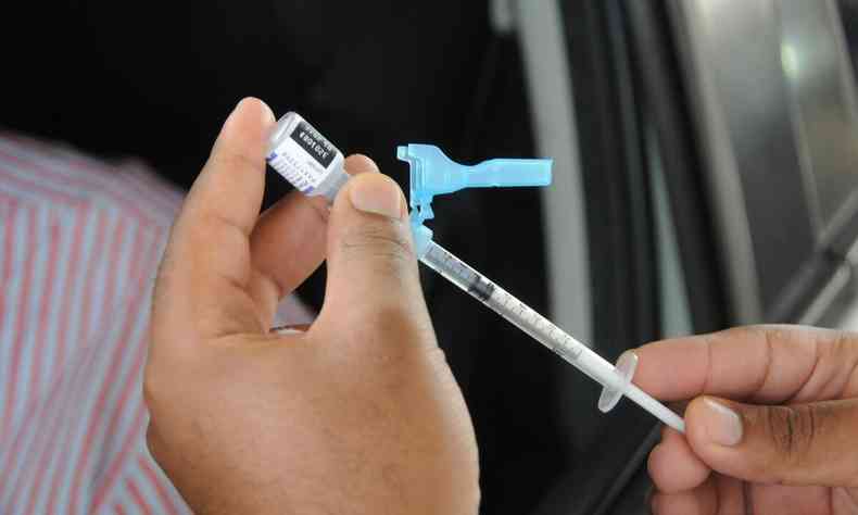Enfermeira segurando seringa contendo a vacina