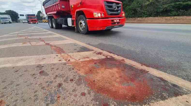 Caminho na rodovia e mancha de sangue no asfalto