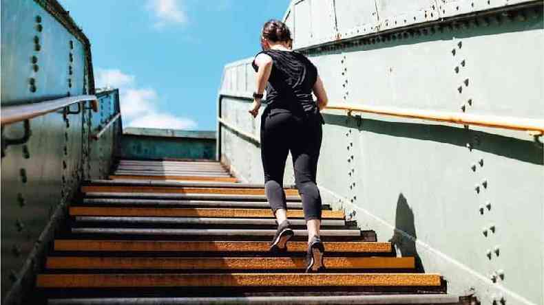 Mulher se exercitando subindo escada
