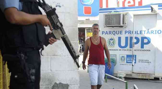 Morador observa policial em Unidade de Poltica Pacificadora(foto: Tnia Rgo/Agncia Brasil)