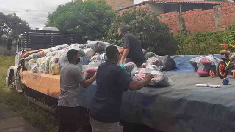 Voluntários descarregam caminhão com doações