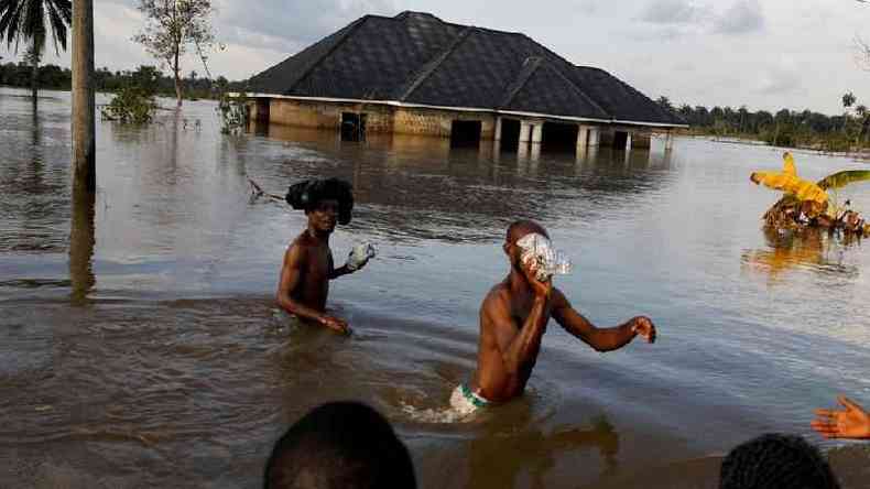 Moradores atravessam gua aps uma grande enchente na comunidade de Obagi, estado de Rivers, Nigria