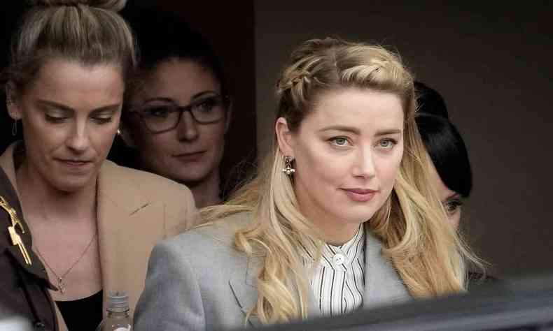 Com penteado de trana no cabelo, atriz Amber Heard se prepara para embarcar em automvel na sada do tribunal