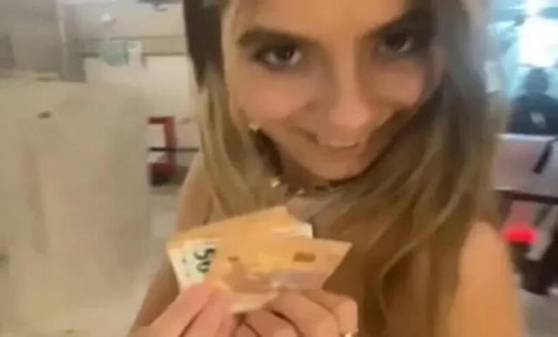 Menina segurando notas de euro