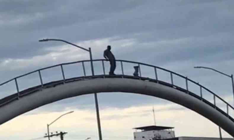 Homem em cima da ponte para pular 