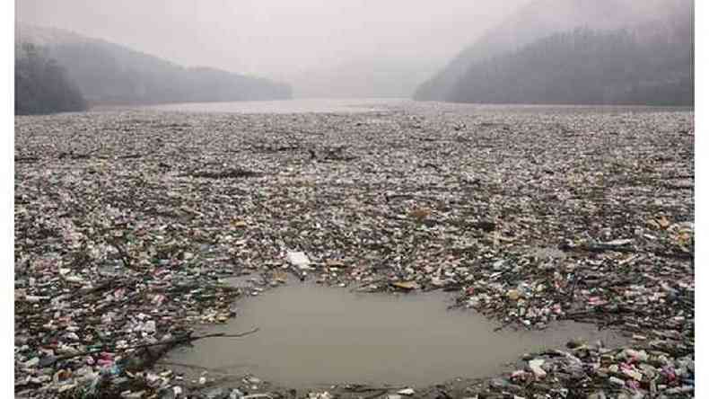 Lago poludo por imensa quantidade de lixo; h tanto lixo que mal d para ver a gua