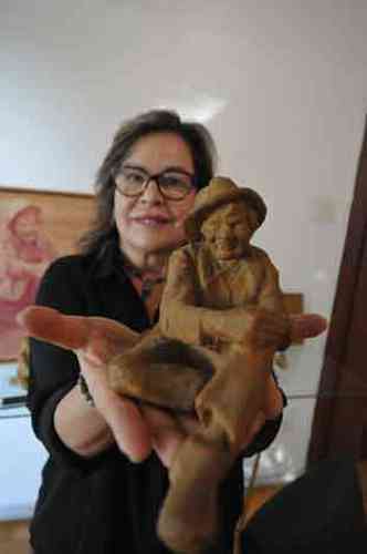 Virgnia segura uma miniatura da escultura do Juquinha
