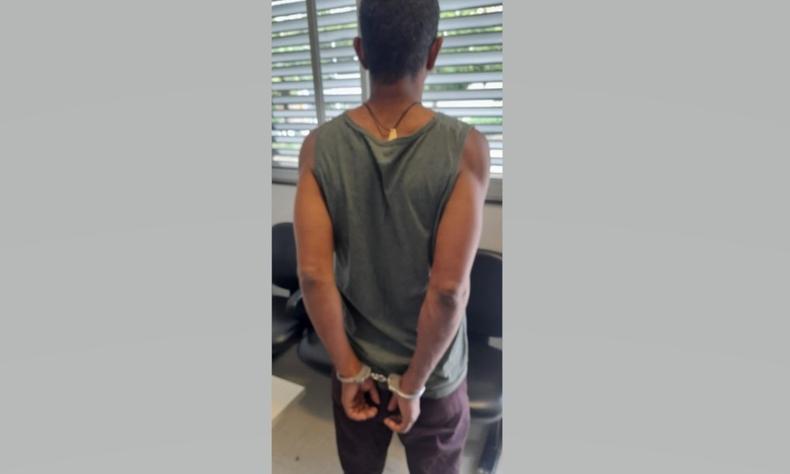 Homem de 45 anos, de camiseta, de costas e alegemado com os braos para trs na delegacia