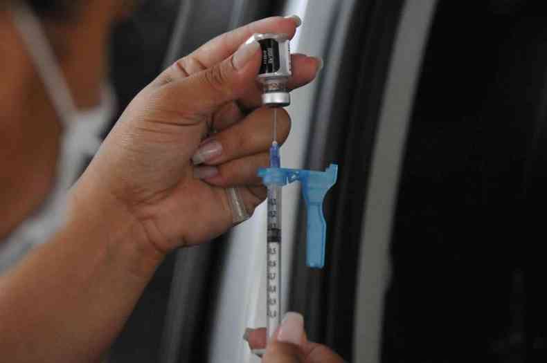 Enfermeira com seringa em posto de vacinao contra a COVID-19 em BH