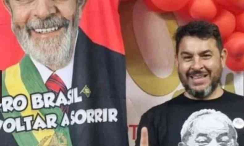 Marcelo Arruda sorrindo para a foto com uma imagem do Lula ao fundo