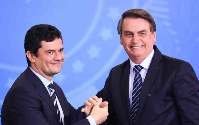 Moro aperta as mãos de Bolsonaro. Os dois sorriem
